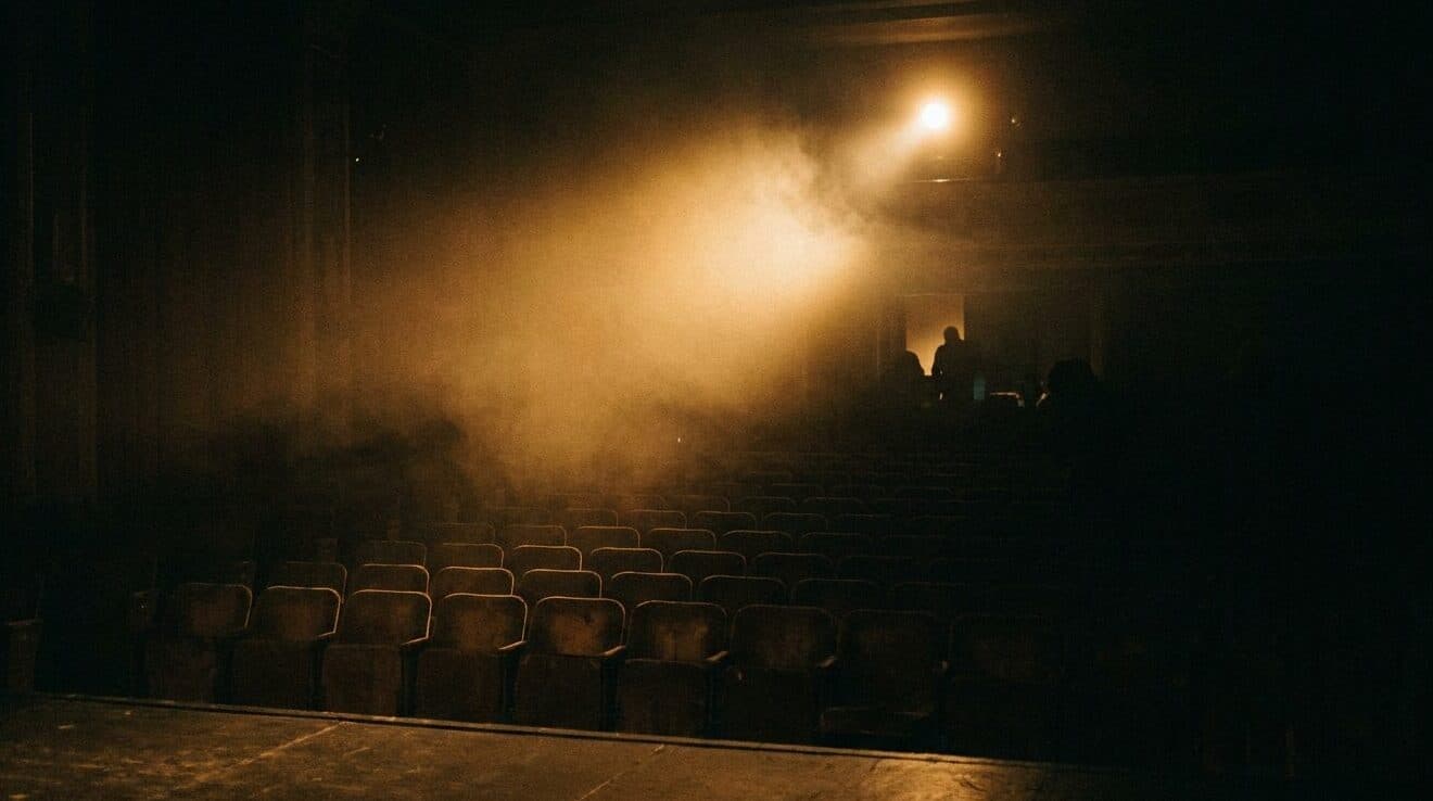 Blick von der Bühne in den dunklen Saal mit leeren Stuhlreihen